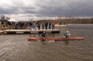 Two Ohio University engineering students paddle in a concrete canoe they built